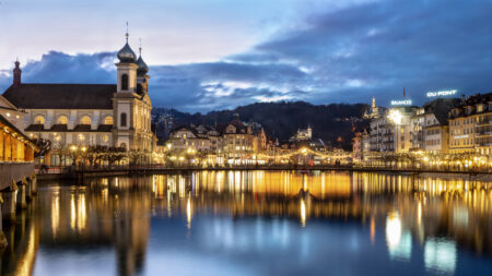 Die Jesuitenkirche St. Franz Xaver am linken Ufer der Reuss in der Altstadt von Luzern bei Nacht, die Aussenbeleuchtung der Umgebung spiegelt sich an der Wasseroberfläche des Vierwaldstättersee