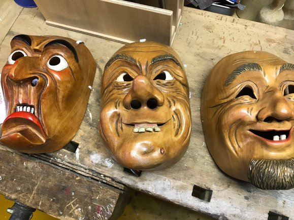 Eine Schreckmaske (links) und zwei fröhliche Charaktermasken nebeneinander.